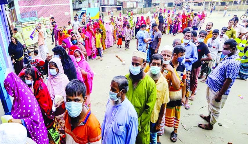 Slum dwellers stand in long queues at Pallibandhu Ershad School in he capital’s Banani area on Wednesday order to get Covid-19 vaccine doses on the occasion of the birthday of Prime Minister Sheikh Hasina.