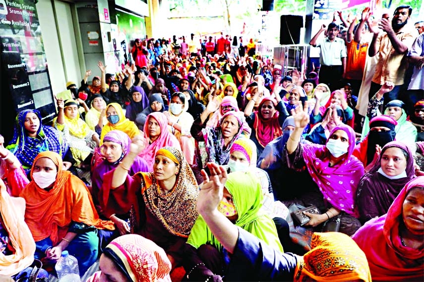 Shramik Kormochari Odhikar Aday Committee sits in a demonstration in front of Shromo Bhaban in the the capital on Sunday demanding payment of 4-month arrear salary of Opex Group Sinha Garments workers.