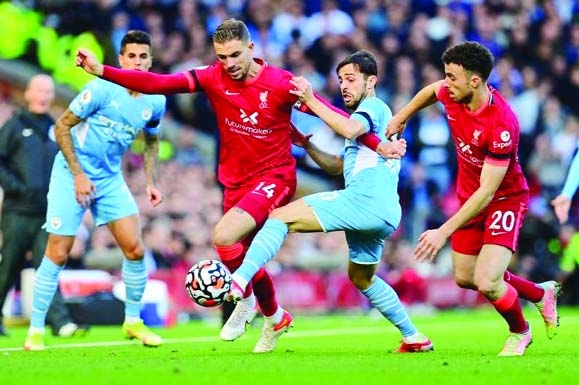 Man City's midfielder Bernardo Silva (2nd from right) challenges Liverpool's midfielder Jordan Henderson (center) and Liverpool's striker Diogo Jota (right) during their English Premier League football match at Anfield in Liverpool, Engla