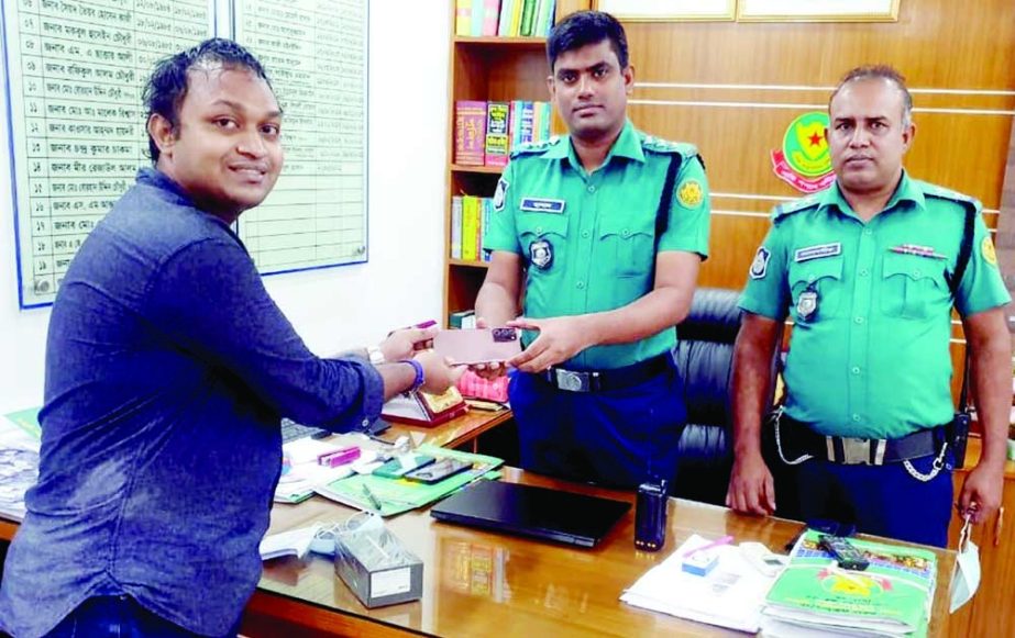 Assistant Commissioner of the city's Palton zone Abul Hossain hands over mobile set which was snatched near RAJUK Bhaban on July 22 last to its owner Farhan Abir on Tuesday. NN photo