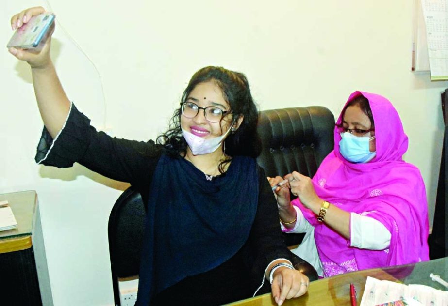 A female student of Dhaka University takes selfie while receiving Covid jab at Martyred Intellectual Dr. Mohammad Mortuza Medical Centre camp on Tuesday. NN photo