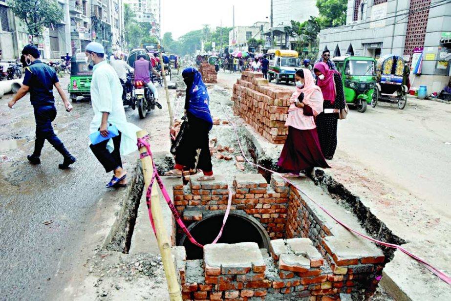 People walk beside an under-constructed drain risking their lives at Chankharpool area on the way to the Dhaka Medical College Hospital emergency wing on Tuesday. NN photo