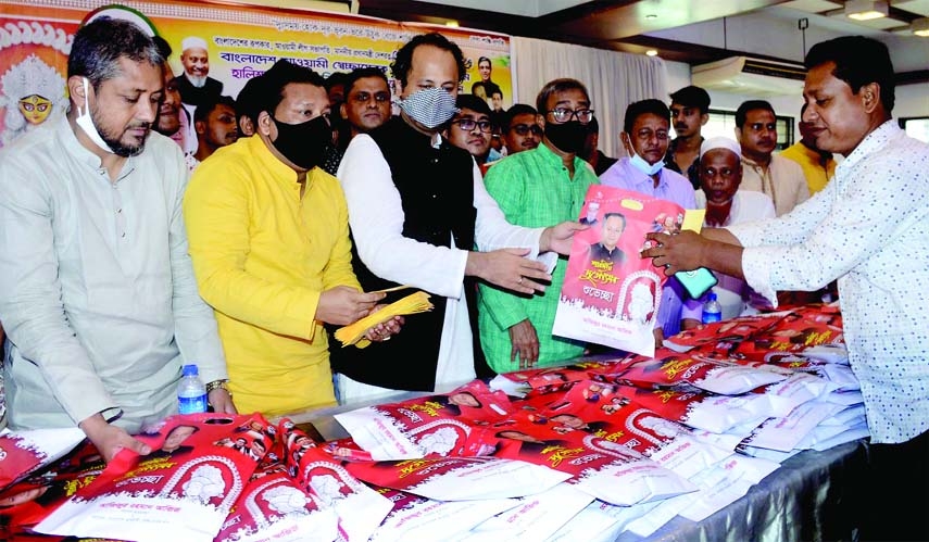 Deputy Education Minister Barrister Muhibul Hasan Chowdhury Nowfel, MP distributes cloth and cash money among the people on the occasion of Durga Puja in Potenga area on Saturday.