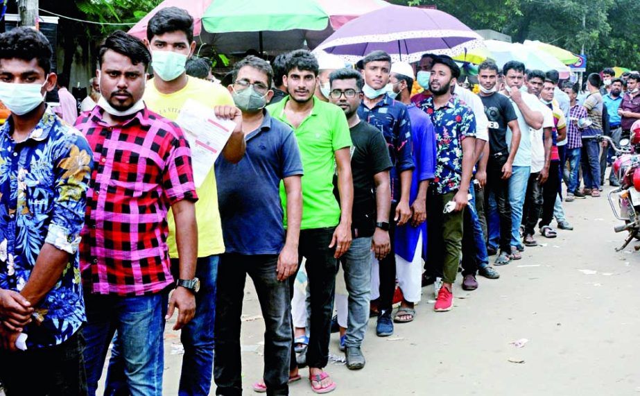 Migrant workers line up at Dhaka Medical College Hospital on Sunday to receive a Covid-19 vaccine before flying to their workplaces abroad. NN photo