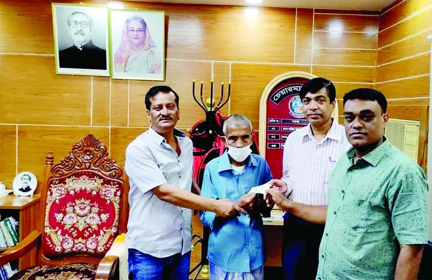 Feni District Council Chairman Khairul Bashar Majumder Tapan on Monday hands over a cash cheque for the treatment of elderly and helpless Sirajul Islam, a resident of Daganbhuiyan Upazila in Feni who has been physically ill. Chief Executive Officer Abu Da