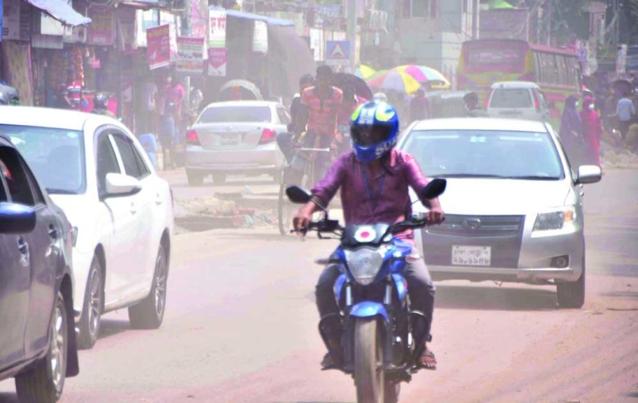 A man drives bike on a road in the capital's Chankharpool area, which is covered with a blanket of dust with the advent of the autumn. NN photo