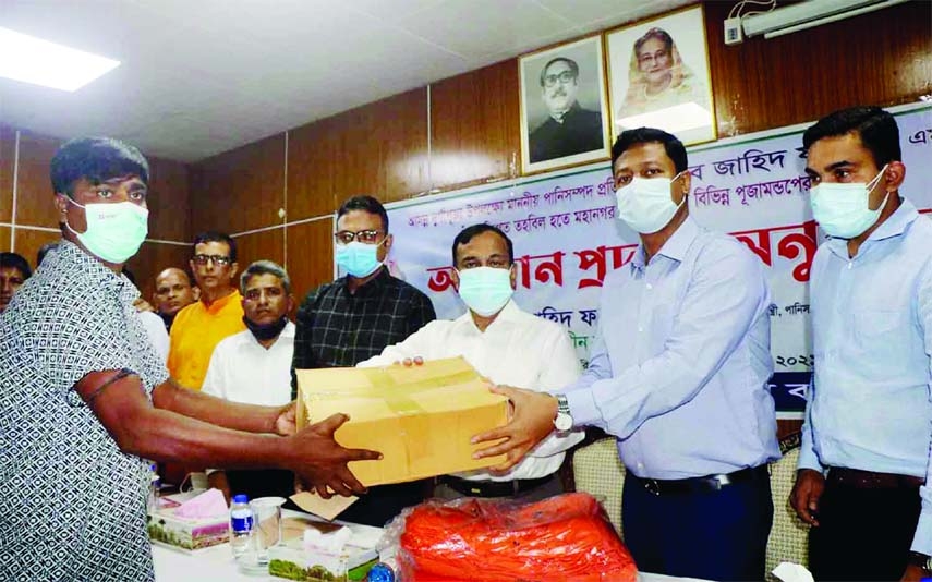 State minister for water resources distributes cheques of grants and presentations at Barishal Circuit House on occasion of Durga Puja on Monday.