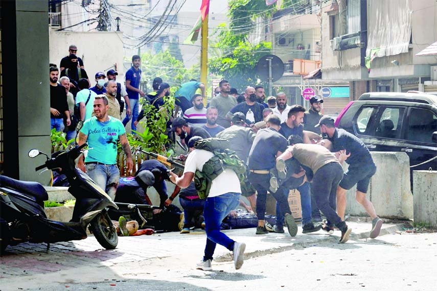 Supporters of a Shia group allied with Hezbollah help an injured comrade during armed clashes that erupted in the southern Beirut suburb of Dahiyeh on Thursday.