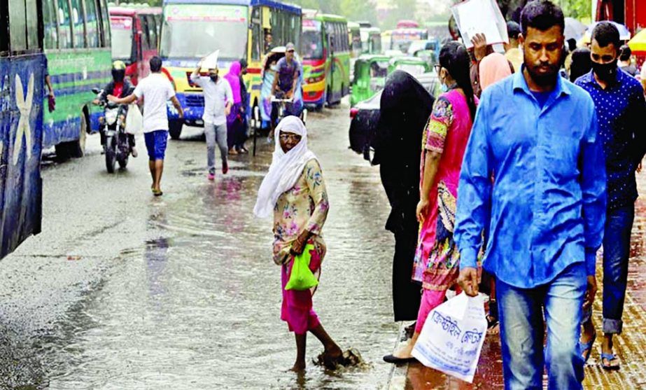 People wait for vehicles at the College Gate area in the capital on Tuesday under a spell of rain. NN photo