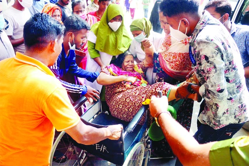 Firefighters and relatives carry an injured woman out of Dhaka's Mugda General Hospital after a fire broke out during maintenance work at an empty ICU on Thursday.