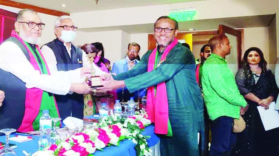 Mukhtar Hossain Mukta, chairman of in Sirajganj receives a crest from Liberation War Affairs Minister AKM Mozammel Haque at a ceremony held on Tuesday. NN photo