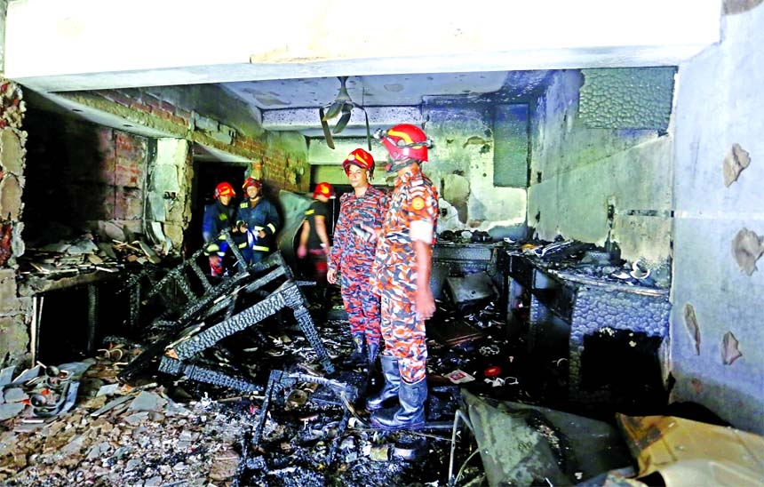 Fire service personnel stand inside a charred floor of a residential building at Gulshan-2 area in the capital on Wednesday. Seven persons received burn injuries in the incident.