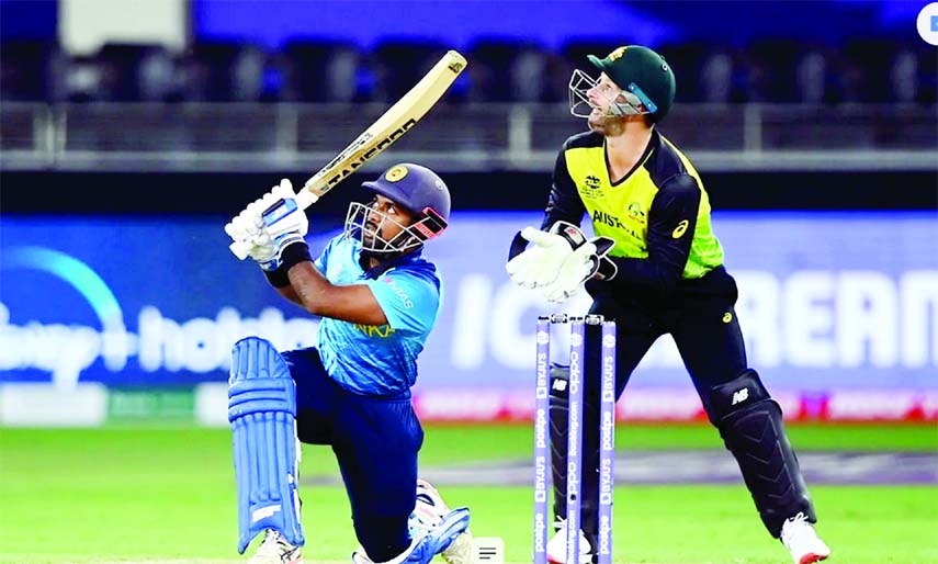 Charith Asalanka (left) of Sri Lanka drives a ball, while wicketkeeper Mathew Wade of Australia looks on during their Group-1 match of the ICC T20 World Cup at Dubai International Stadium in the United Arab Emirates on Thursday.