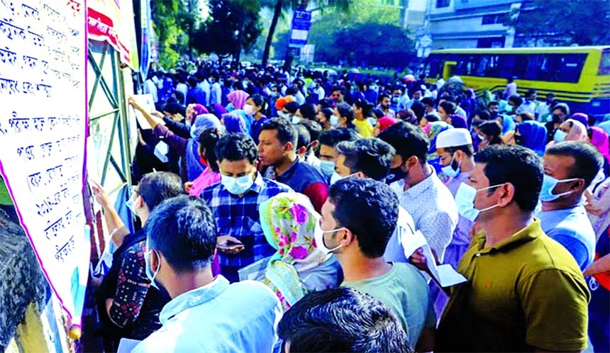 Candidates look at seat plan outside the gate at Mirpur College in the capital on Friday as the 43rd BCS Preliminary Examination began across the country.