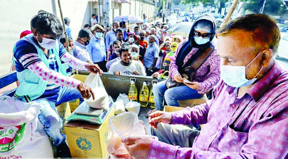 A huge number of middle-income group people are also standing in the queues to buy commodities from TCB trucks due to abnormal price hike of essential goods in the markets. This photo was taken from city's Topkhana road on Wednesday. NN photo