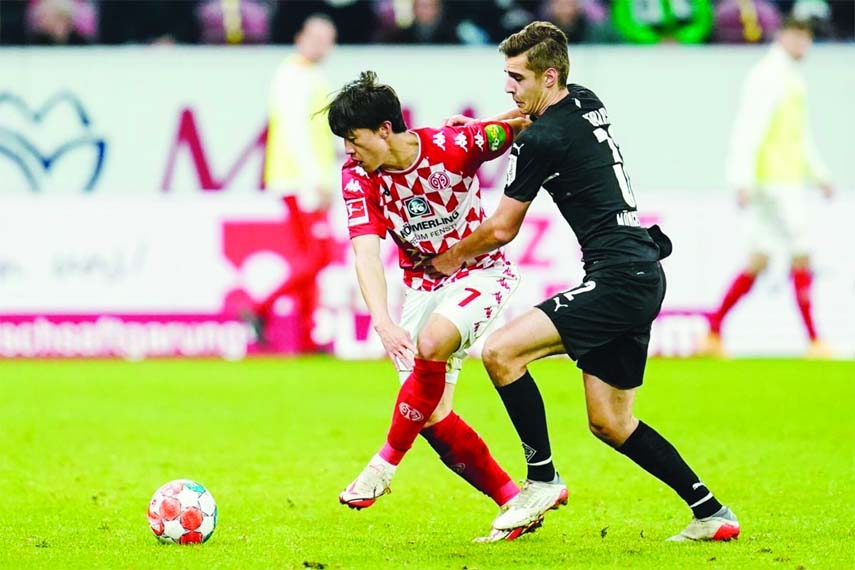 Mainz's Jae-Sung Lee (left) and Gladbach's Florian Neuhaus fight for the ball during the Bundesliga soccer match between Mainz and Borussia Moenchengladbach at Mewa Arena in Mainz, Germany on Friday.