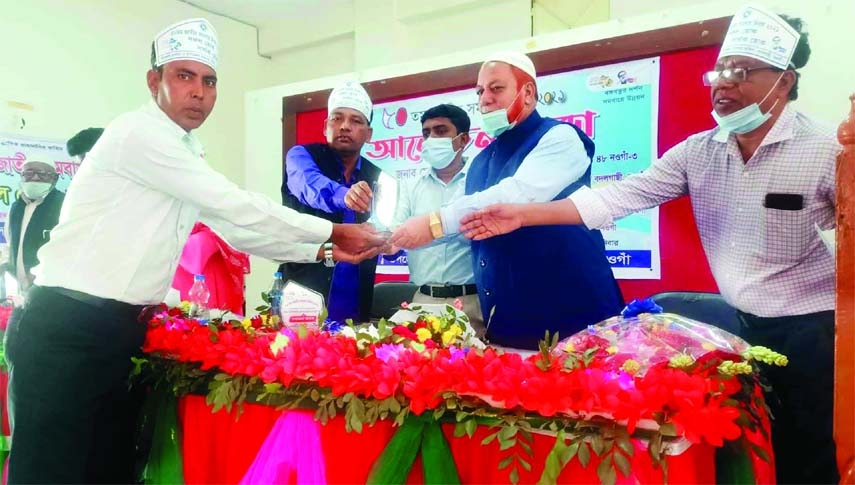 Badalgachhi Upazila Parishad Chairman and the Chief Guest Shamsul Alam Khan handing the crest to a co-operative personality at a programme in the upazila on Saturday.