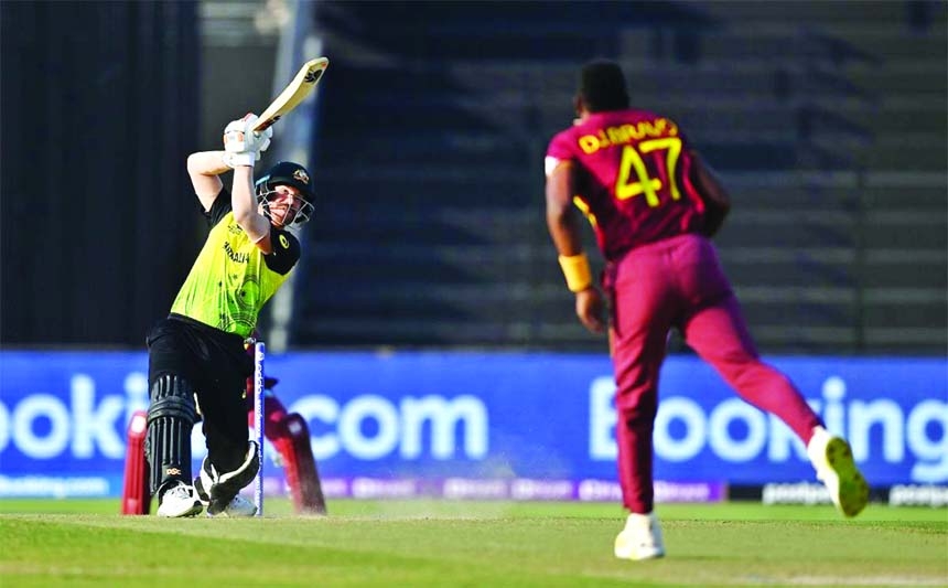 Australia's David Warner (left) plays a shot during the ICC men's Twenty20 World Cup cricket match between Australia and West Indies at the Sheikh Zayed Cricket Stadium in Abu Dhabi on Saturday.