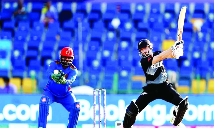 Kane Williamson (right) of New Zealand plays a cut, while wicketkeeper Mohammad Shahzad of Afghanistan tries to grip the ball during their last Group-2 match of the ICC T20 World Cup at Sheikh Zayed Cricket Stadium in the United Arab Emirates on Sunday.