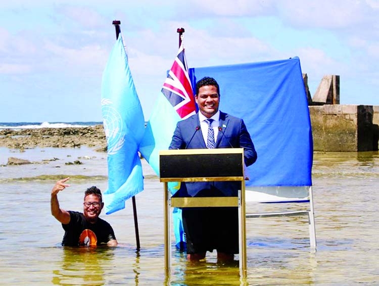 Tuvalu Minister Simon Kofe gives a COP26 statement while standing in the ocean in Funafuti, Tuvalu.