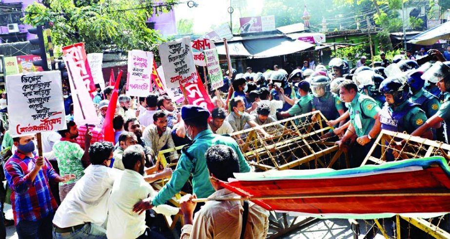 Left Democratic Alliance (LDA) activists try to take down a police barricade set near the National Press Club on Monday as cops thwarted their procession towards Bangladesh Secretariat to protest against recent fuel price hike. NN photo