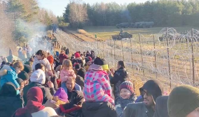 Migrants gather near a barbed wire fence on the Poland - Belarus border in Grodno District, Belarus, in this still image taken from a social media video on November 9, 2021. Photo: Reuters