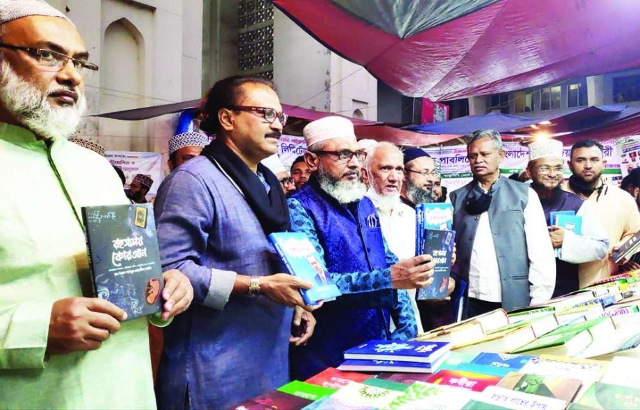 Editor of the daily Naya Diganta Alamgir Mahiuddin, among others, holds the copies of threes books including 'Global Politics Turkey Erdogan' at its cover unwrapping ceremony at Baitul Mokarram Islamic Book Fair in the city on Tuesday. NN photo