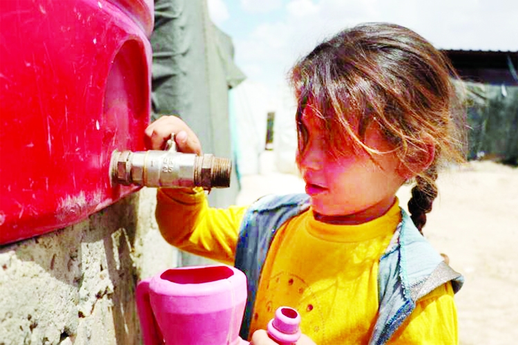 A Syrian girl fetches water from a tank in the al-Hol displacement camp in northeast Syria.