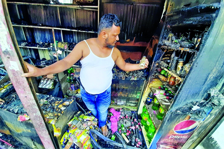 A man stands in a charred shop at Jatrabari area in the city on Friday after a fire broke out due to electric short circuit.