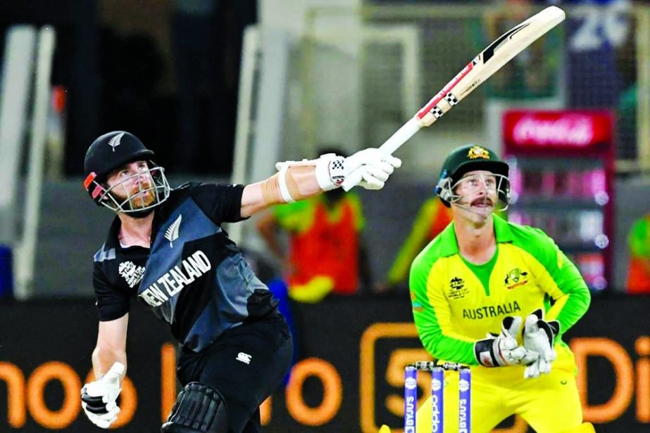 Kane Williamson (left) of New Zealand drives a ball, while wicketkeeper Mathew Wade of Australia watches during their final match of the ICC T20 World Cup at Dubai International Stadium in the United Arab Emirates on Sunday. Agency photo