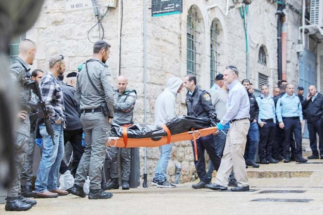 Israeli medics carry the body of a Palestinian man who was fatally shot by Israeli occupation forces after he killed a settler and wounded three others in an armed confrontation in Jerusalem's Old City on Sunday.