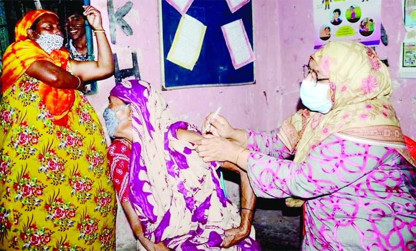 A health worker administers Covid-19 vaccine jab on a woman in Jhautla Chhinnamul slum area of Chattogram City on Sunday.