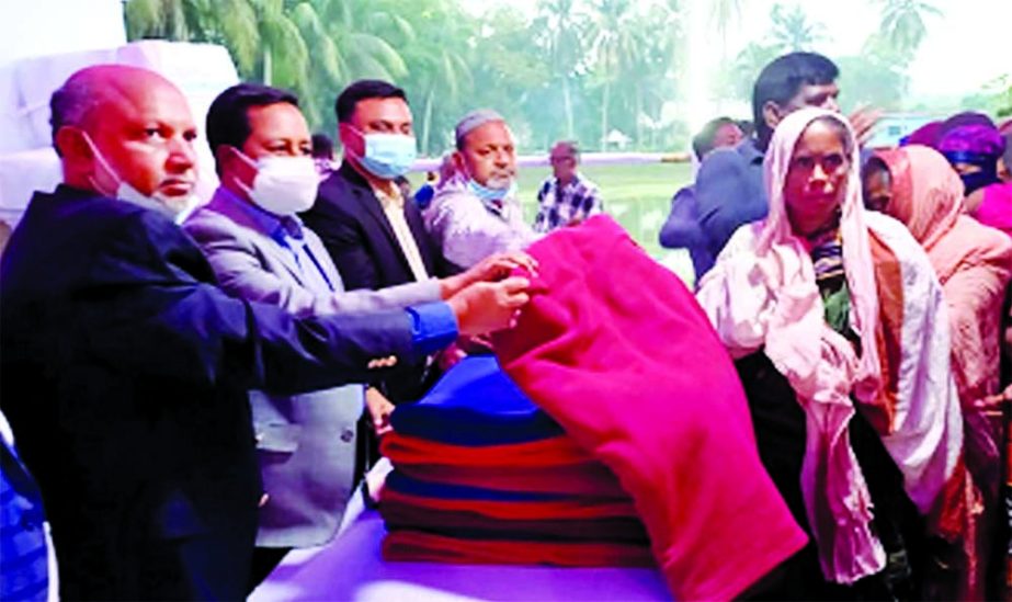 Faridpur DC Atul Sarkar, distributing winter clothes among the poor people arranged by Premier Bank Limited at Saheb Bari of Gerda in Faridpur as chief guest recently. Syed Nowsher Ali, DMD, senior officials of the bank and local elites were present.