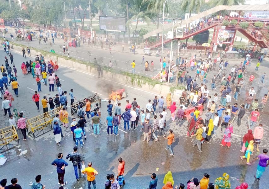 Garment works stage demonstration blockading roads at Mirpur area in the capital on Wednesday demanding salary hike.