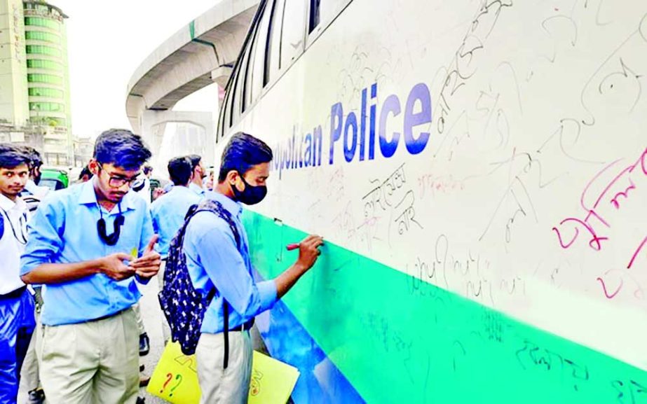 Protesting students write different slogans, including "why do the police not have a licence?" on a DMP bus in the capital on Thursday after its driver failed to show licence. NN photo