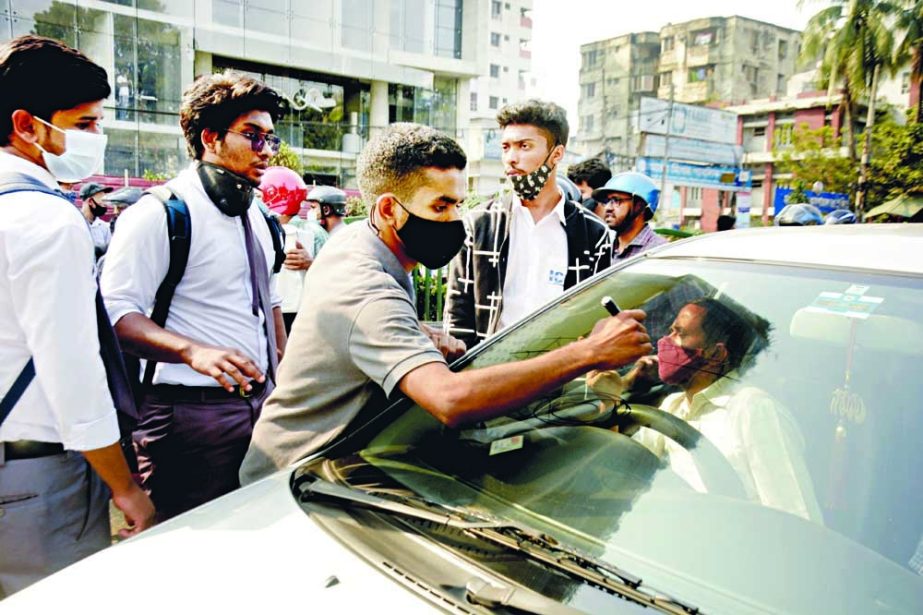 Students check the papers of a car driver during a protest for road safety at Dhanmondi Road 27 in the capital on Saturday. NN photo