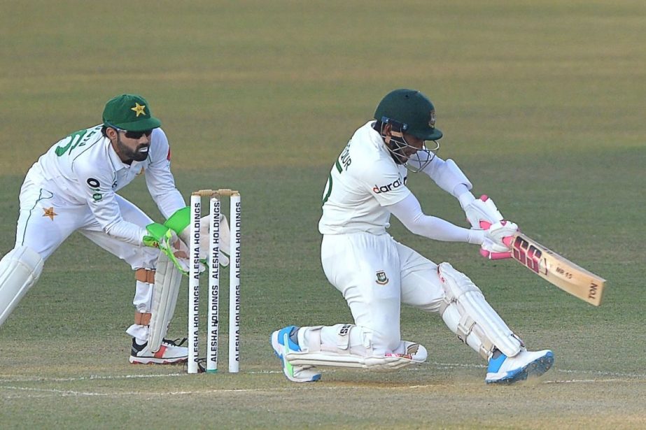 Mushfiqur Rahim (right) of Bangladesh plays a sweep shot, while Pakistani wicketkeeper Mohammad Rizwan looks on during the day 3 play of the first Test match at the Zahur Ahmed Chowdhury Stadium in Chattogram on Sunday. NN photo