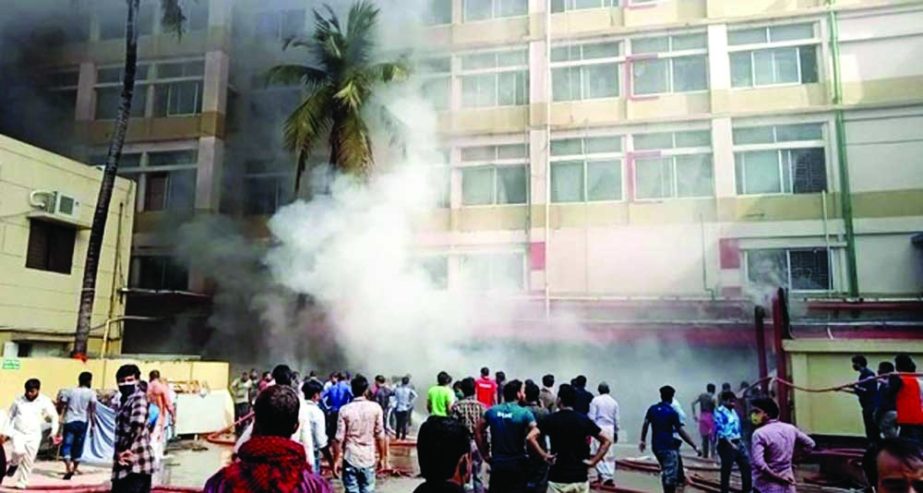 People stand in front of a knit-wear factory at Jarun area of Konabari in Gazipur where a fire broke out on Tuesday. NN photo