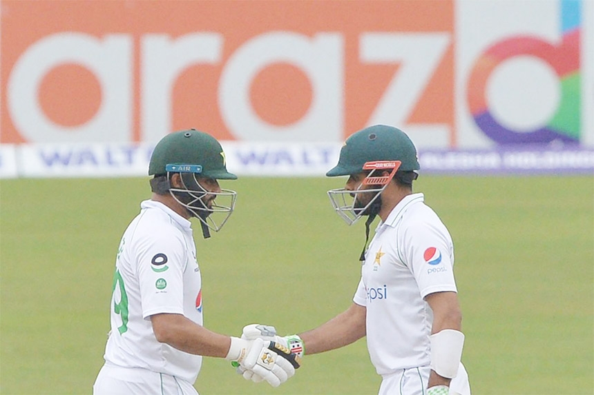 Azhar Ali (left) and Babar Azam of Pakistan shaking hands after sharing a 100-run partnership together against Bangladesh on the day 2 of the first Test at the Sher-e-Bangla National Cricket Stadium in the city's Mirpur on Sunday.