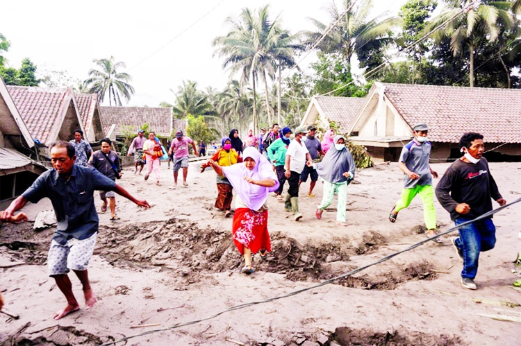 People inspect their village buried with volcanic ash from the Mount Semeru eruption at Sumber Wuluh village in Lumajang, East Java, Indonesia.