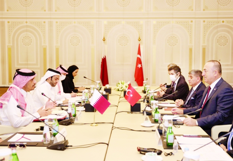 Turkish Foreign Minister Mevlut Cavusoglu, right foreground, and Qatari Foreign Minister Sheikh Mohammed bin Abdulrahman Al Thani, left foreground, meeting in Doha.