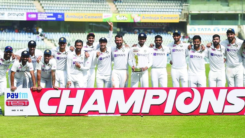 India's cricketers pose for pictures with the trophy after winning the fourth day of the second Test cricket match between India and New Zealand at the Wankhede Stadium in Mumbai on Monday.