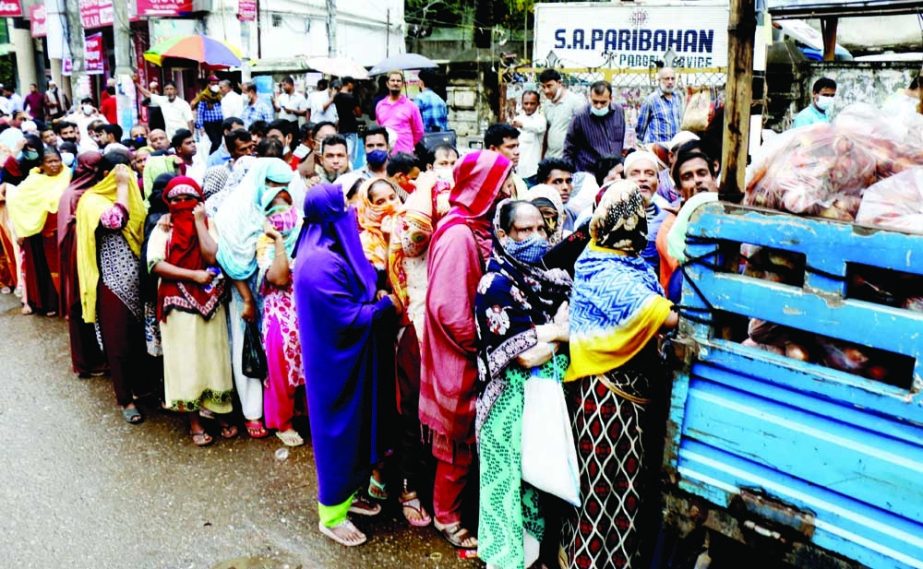 People stand in long queues at Kakrail area in the capital on Tuesday in order to buy OMS products from TCB truck. NN photo