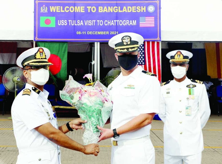 Chief Staff Officer of Chattogram Naval Zone Captain Masudul Karim Siddiqui welcomes Captian of US Navy Warship 'USS TULSA' Commander William Devorak giving bouquet when the ship reaches Chattogram Port on Wednesday. ISPR photo