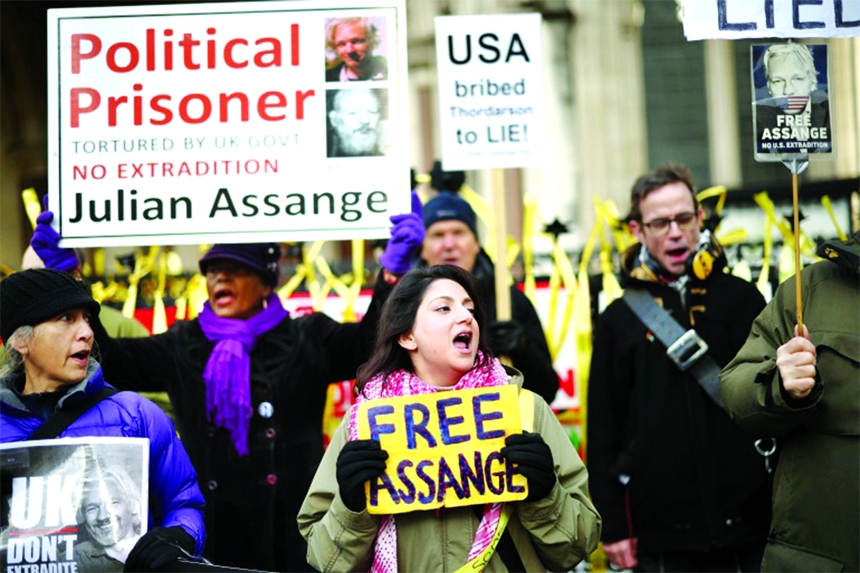 Supporters of Julian Assange hold signs outside the Royal Courts of Justice in London, Britain on Friday.
