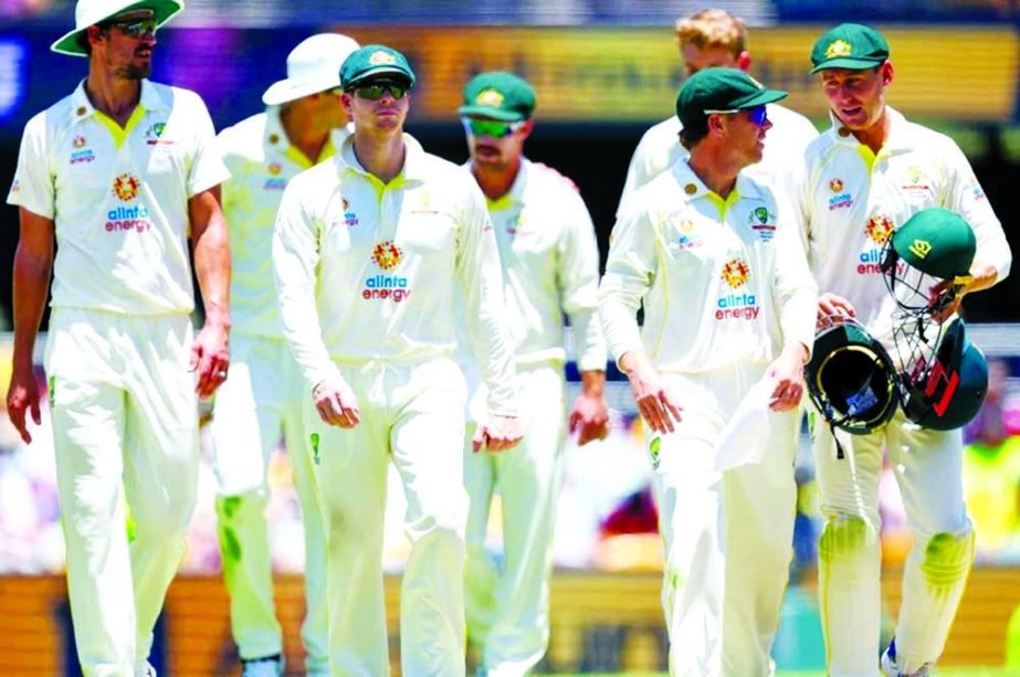 Australia's players walk off the field after dismissing England during day four of the first Ashes cricket Test match between England and Australia at the Gabba in Brisbane on Saturday. Agency photo