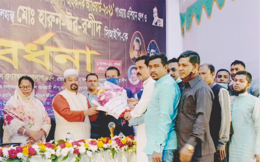 Dr Abdus Sobhan Golap, MP, Office Secretary of Bangladesh Awami League, greetings with bouquet to Harunur Rashid, CIP, Chairman of Asian Group for achieving the Nepal Int'l Iconic Award-2021 at a function held at Asian TV office in the capital recently.