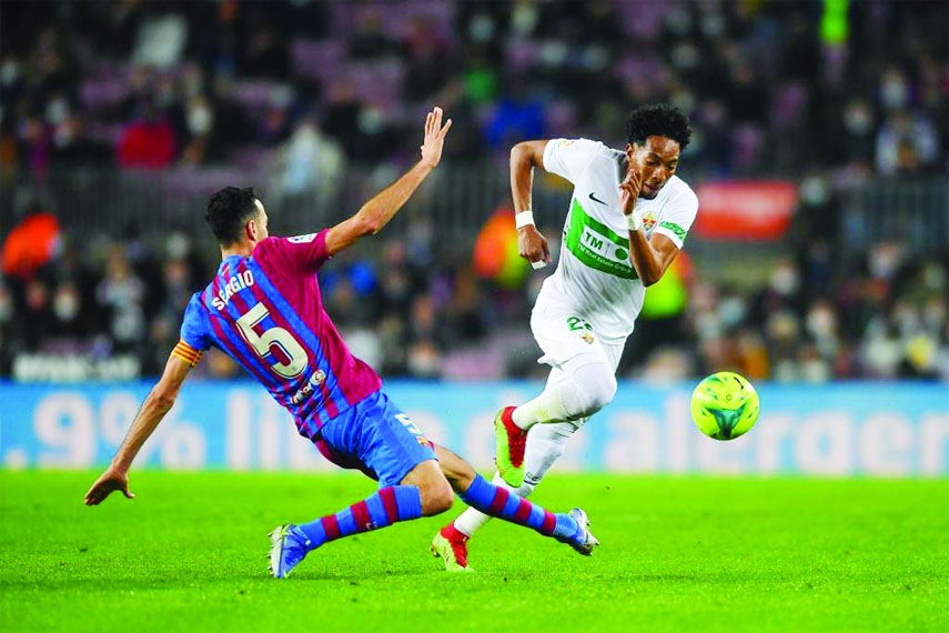 Barcelona's Sergio Busquets (left) vies with Elche's Johan Mojica during a Spanish first division league football match between FC Barcelona and Elche CF in Barcelona, Spain on Saturday.