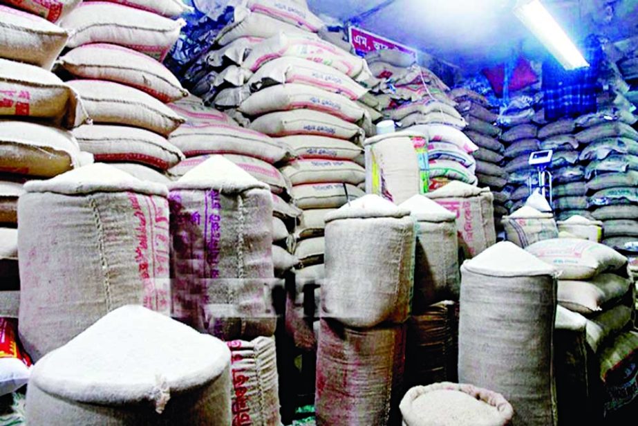Sacks of rice are stacked at a warehouse in the capital's Badamtoli wholesale market on Thursday. NN photo