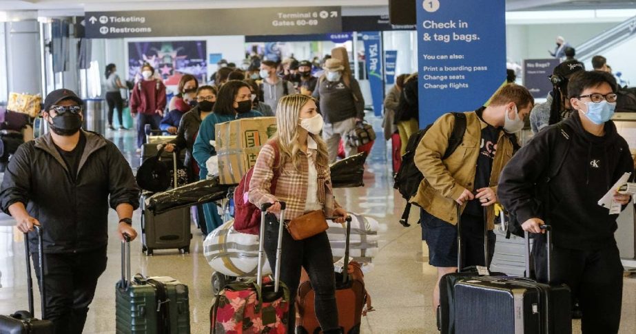 Holiday travelers wearing face masks line to check in at the Los Angeles International Airport in Los Angeles, Wednesday, Dec. 22, 2021. AP photo
